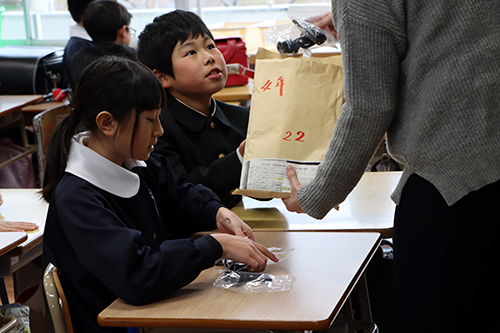 帰りの会で鈴が配布される様子
