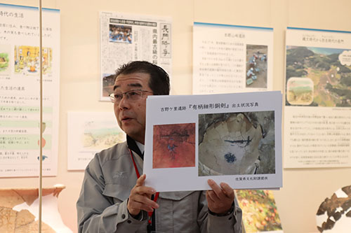 吉野ケ里遺跡出土の銅剣と同型で貴重だと話す、新江田学芸員