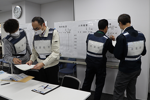 避難所の状況、被害状況、停電情報などをホワイトボードに整理する様子