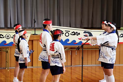 6年生から在校生へ鯨唄を継承する様子