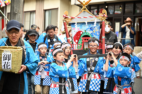 神輿を担いで温泉街を歩く様子