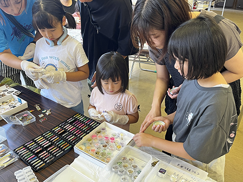 ビーズなど飾りを選ぶ子どもたち