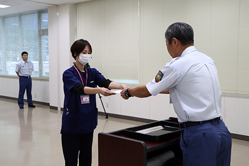 岩本消防長から委嘱状を受ける日高さん