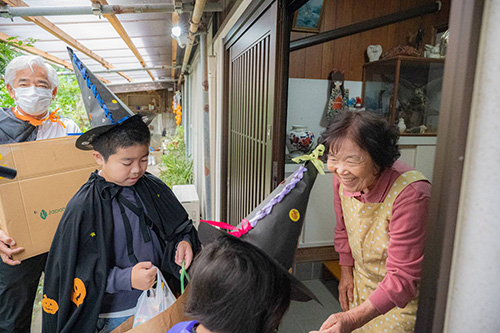 敬老会のお祝いの品を渡す子ども