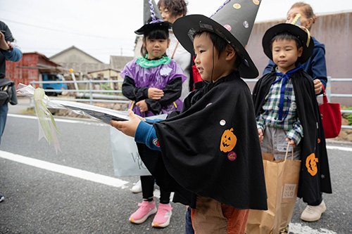 敬老会のお祝いの品を渡す子ども