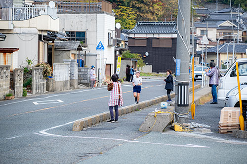 沿道を走る児童と応援する地域の方