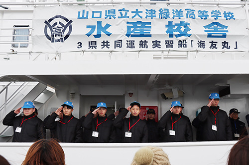 見送りに来た保護者や教職員、生徒へ敬礼