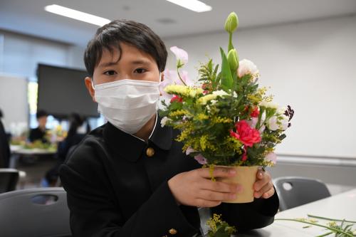 完成したアレンジメントを持つ児童