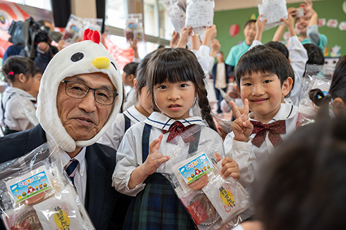 お菓子をもらった園児と末永組合長
