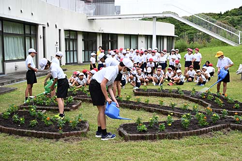 水やりのお手本を見せる6年生児童