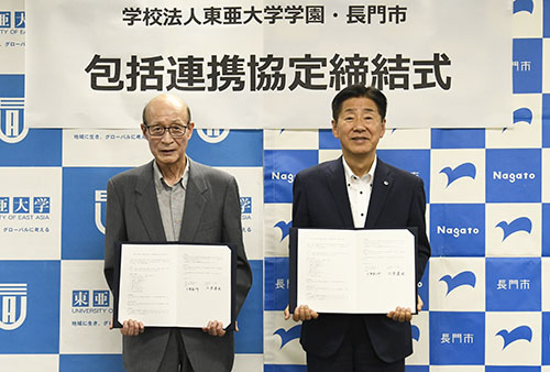 協定書を手にする百瀬理事長（左）と江原市長
