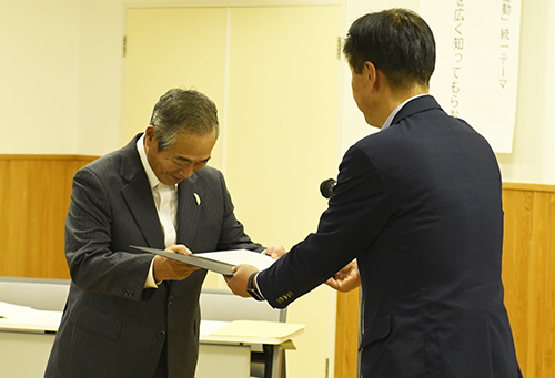 メッセージ文を手渡す安藤会長（左）