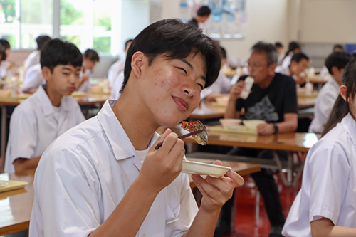 笑顔で仙崎トロあじを食べる生徒