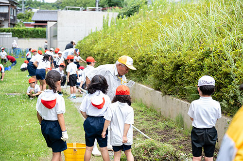 草取りをする児童と地域の方