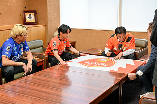 江原市長が応援メッセージを書く様子