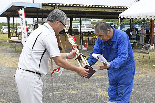 表彰式でトロフィーを受け取る平尾さん