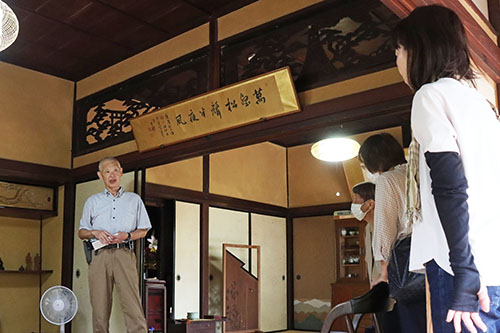 主屋で説明する岡藤浩史さん(左)