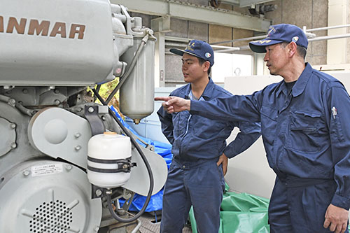 恋塚教諭（右）とエンジンの動作確認を行う大林さん