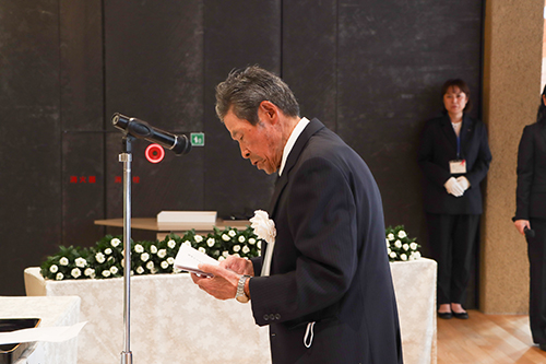 追悼のことばを述べる花岡会長