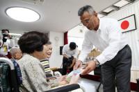 深川養鶏農業協同組合の末永組合長から手渡しでお菓子がプレゼントされる