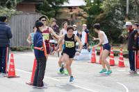 宗頭文化センター前で3区の岡野さんから4区の高見さんへタスキリレー