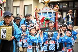神輿を担いで温泉街を歩く様子