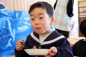くじらの竜田揚げを食べる園児