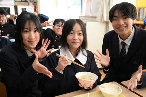 ふくつみれ鍋を持つ児童と山下さんと小林さん