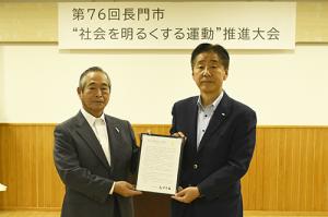 高市内閣総理大臣のメッセージを手にする安藤会長(左)と江原市長