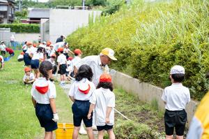 草取りをする児童と地域の方