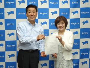 諮問書を手にする河野会長（右）と江原市長