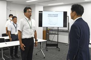 帰任したことを江原市長に報告する山下課長補佐(中央)